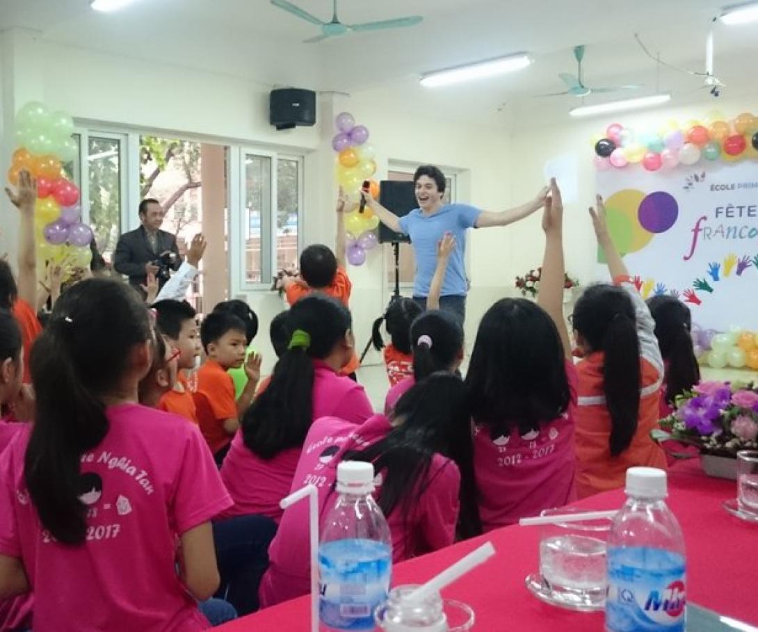 A participant from the Westpoint University volunteer group speaks to Vietnamese students in Asia. A student from Westpoint University gives a presentation to children in Vietnam during his group volunteer trip.